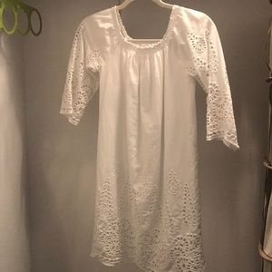 White dress w patterns at the bottom and sleeves